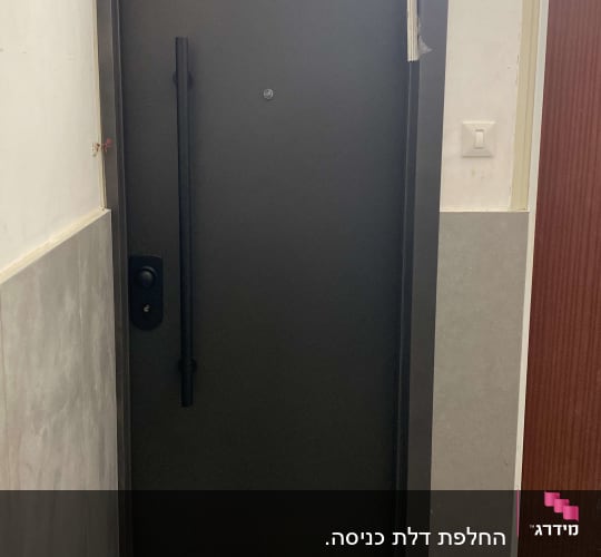 דלת מתכת כהה עם ידית ארוכה ופס דבק